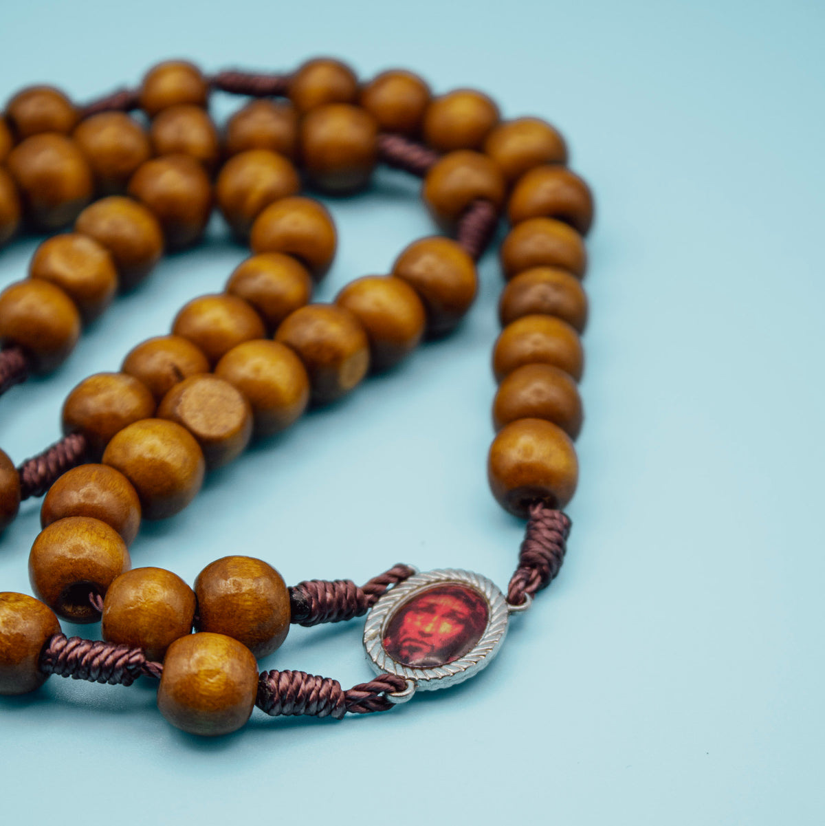 1. Holy Face of Jesus centerpiece on brown wooden Rosary
