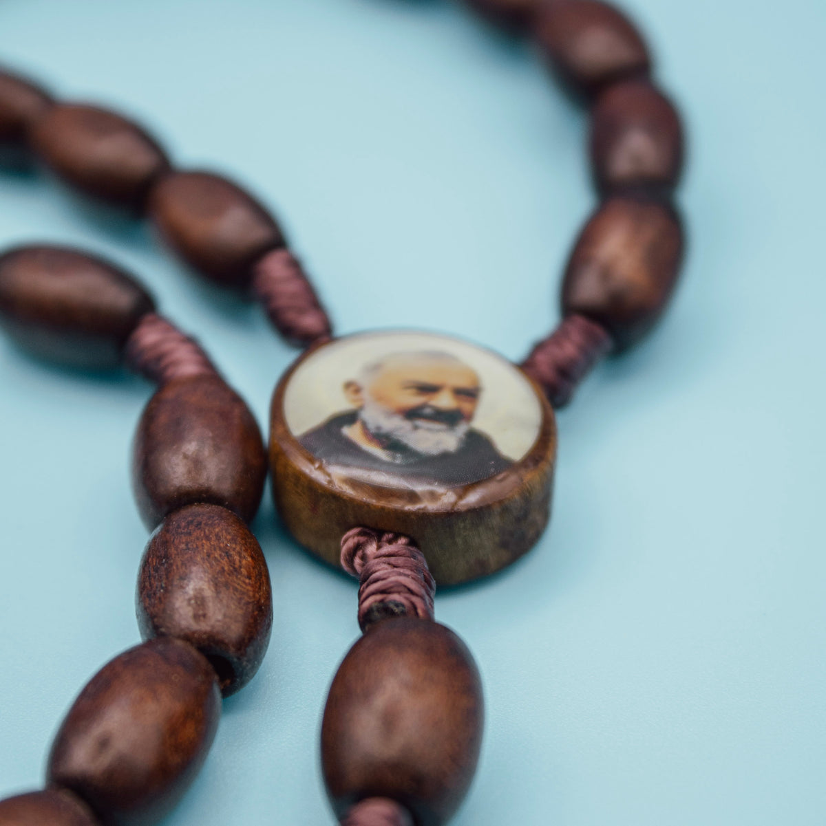 Close-up of Padre Pio centerpiece on wooden Rosary