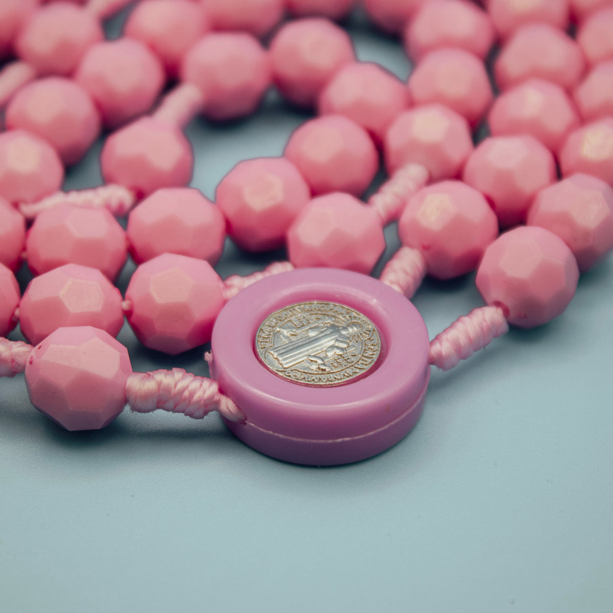 Close-up of Saint Benedict Medal centerpiece on pink Rosary