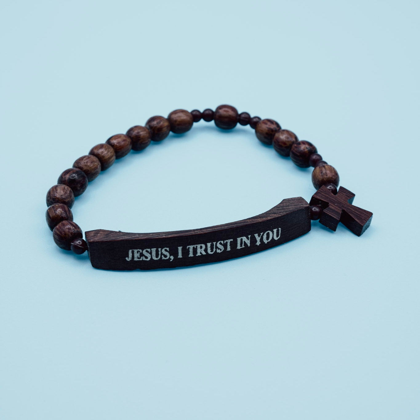Wooden bracelet with engraved message on a light blue background