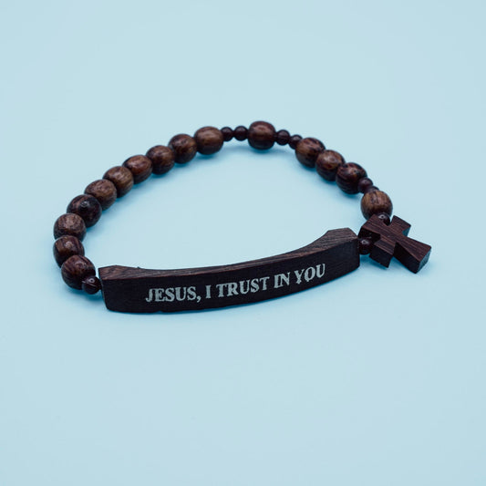 Wooden bracelet with engraved message on a light blue background